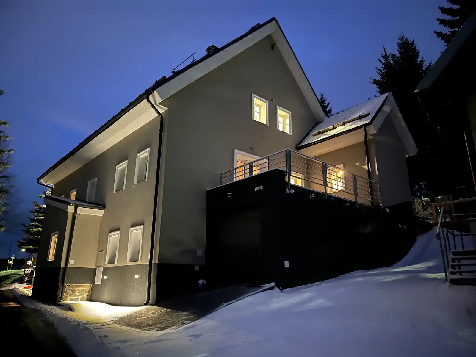 Hillside 18 an einem Winterabend mit beleuchteten Fenstern und Schnee