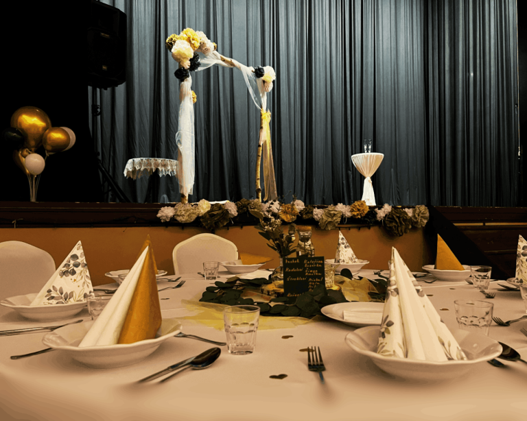 Svatební dekorace stolů a slavobrána v pozadí