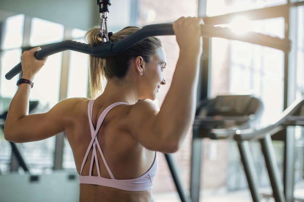 Athletische Frau trainiert im Sportraum des Hotels